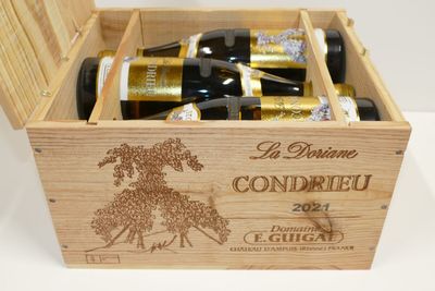 bouteilles de vin dans un coffret en bois sur une surface blanche