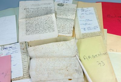 a pile of old papers on a table with writing on them
