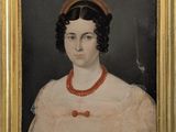 portrait d'une femme en robe rose portant un collier de perles rouges