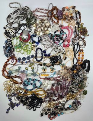 a close up of a pile of assorted jewelry on a white surface