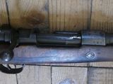 a rifle that is sitting on a wooden floor