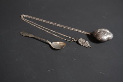 deux cuillères en argent et une boule en argent posées sur un fond noir