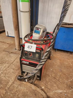 un gros plan d'une machine à souder à laquelle est raccordé un tuyau