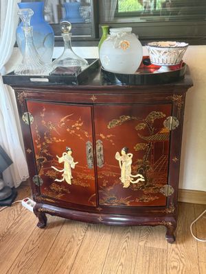 a cabinet that has a vase on top of it