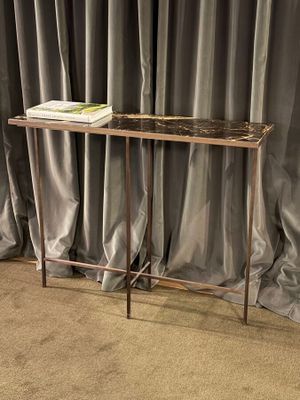 a table with a book on top of it in front of a curtain