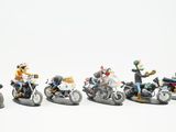 cinq figurines représentant des personnes à moto sur un fond blanc