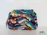 un sac à main multicolore posé sur une table blanche