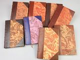 six leather journals with different patterns and colors on them