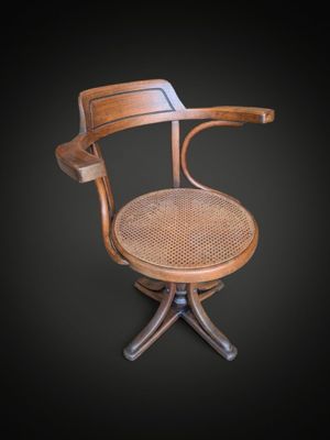 une image représentant une chaise en bois avec une assise en osier sur fond noir