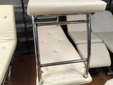 trois chaises blanches et une table dans une pièce