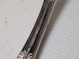 a silver spoon with a flower design on it