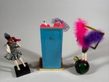three figurines that are standing next to a trash can
