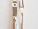 deux fourchettes et un couteau sur une table blanche