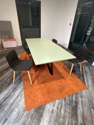 une table et des chaises dans une pièce avec du parquet