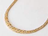 an image of a gold necklace on a white surface