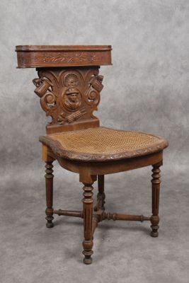 une vieille chaise en bois avec une assise en osier, sur fond gris