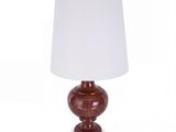 une lampe de table rouge surmontée d'un abat-jour blanc