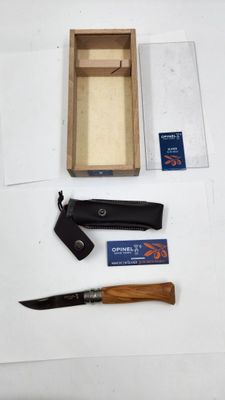 un couteau, un aiguiseur et une boîte posés sur une table