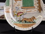 a plate with a picture of a dog and a man on a horse