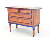a small chest of drawers on a small table