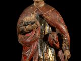 an old wooden statue of a woman holding a basket