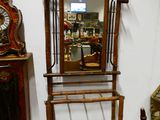 un miroir posé sur un pied à côté d'une horloge