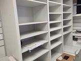 a room with a lot of shelves and a phone on the desk