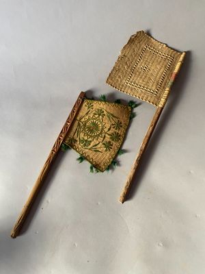 a small piece of wood and a small piece of woven material on a white surface
