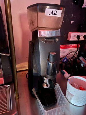 a coffee maker sitting on a counter next to a cup of coffee