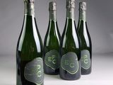 three bottles of champagne with a green label and a white background