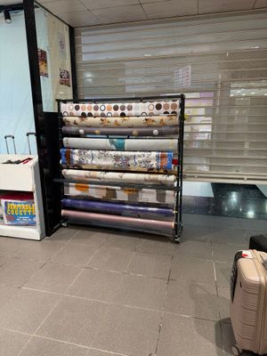 de nombreux rouleaux de tissu posés par terre dans le magasin