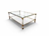 a glass and brass coffee table on a white background