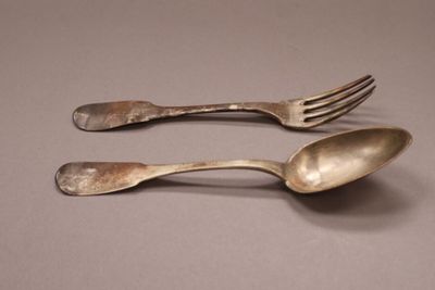 two spoons and a fork sitting on a table