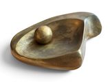 un objet métallique contenant une boule, posé sur une surface blanche