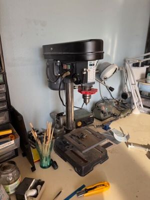 un établi sur lequel se trouvent une perceuse et de nombreux outils