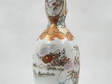 a vase with a bird on it sitting on a table