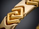 a close up of a gold bracelet on a black background