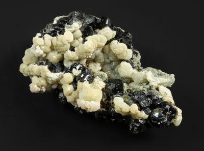 un gros plan sur un morceau de roche comportant des cristaux noirs et blancs