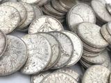 une pile de pièces d'argent posée sur une surface blanche