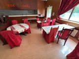 une grande salle avec des tables et des chaises recouvertes de nappes rouges