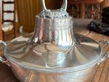 a silver bell sitting on top of a wooden table