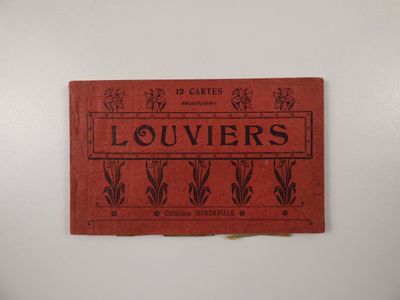 un vieux livre rouge avec des inscriptions noires, posé sur une surface blanche