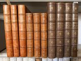Plusieurs vieux livres sont empilés sur une étagère dans une bibliothèque