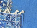 two blue rugs on a wooden floor with a blue and white rug