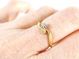 a woman ' s hand with a diamond ring on it