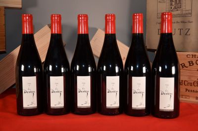 six bottles of red wine are lined up on a table