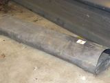 a pipe that is laying on the ground next to a car