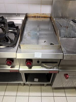 stainless steel counter top with two burners and a fryer
