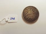 a silver coin with a tag on it next to a white tag