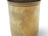 a gold pot that is sitting on a white surface